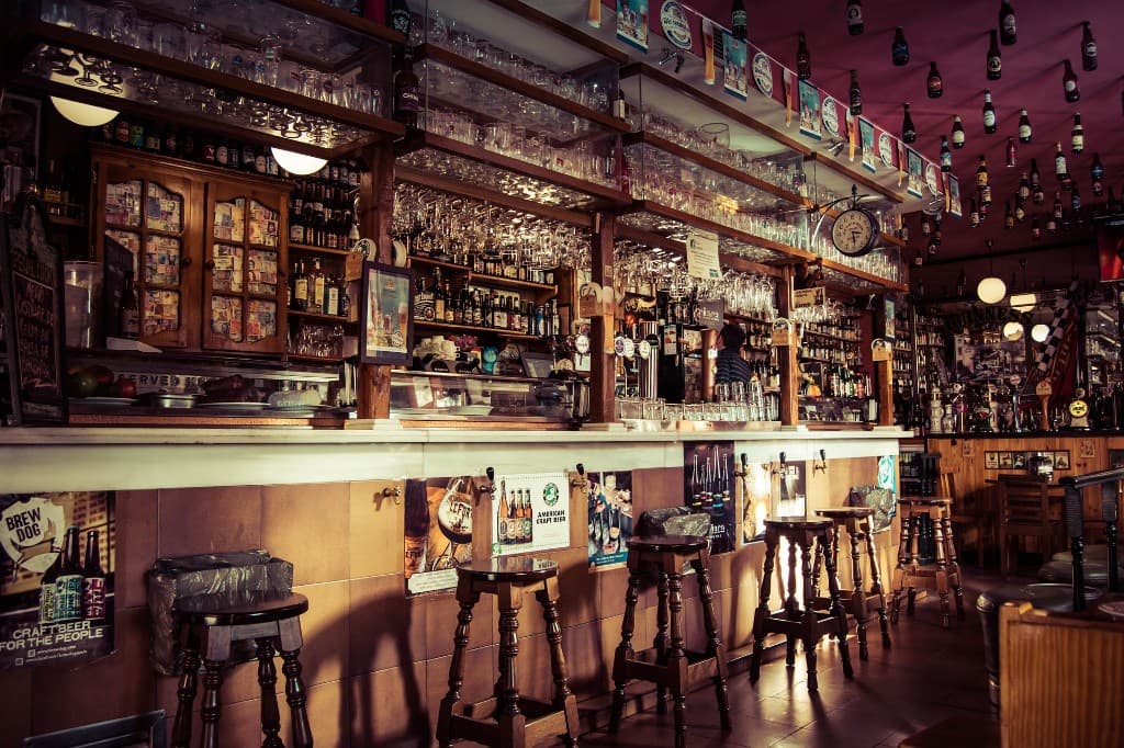 Classic pub bar with bottles, glassware, and bar seating